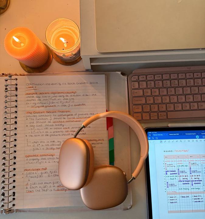 Gezellige studieplek met kaarsjes, notities en een koptelefoon